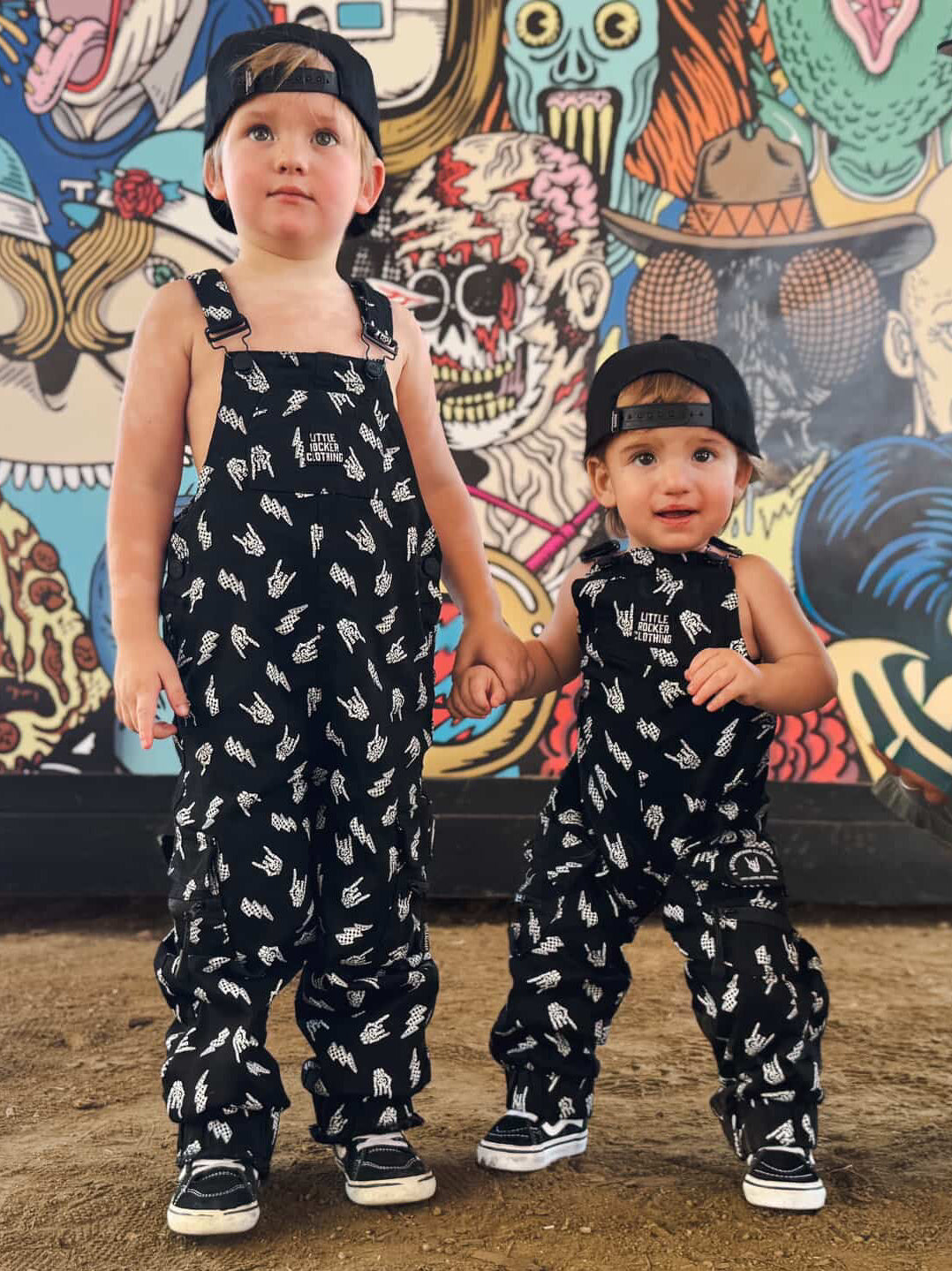 two boys wearing kids black bolted bones overalls with lightning bolt and rock hand print matching outfits toddler streetwear little rocker clothing