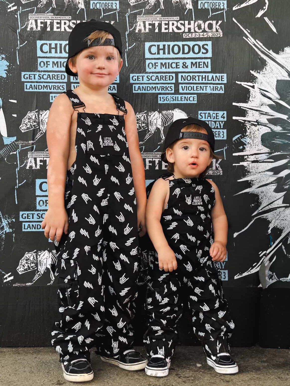 boys at aftershock music festival wearing kids black bolted bones overalls with lightning bolt and rock hand print matching outfits toddler streetwear little rocker clothing