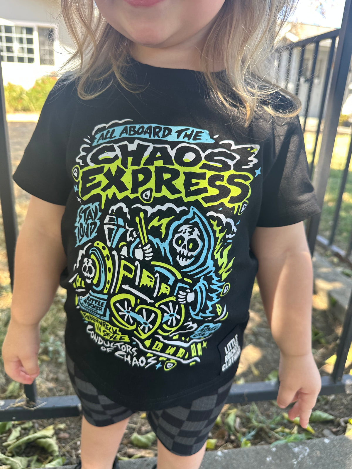 Close up of a toddler wearing the Kids black chaos express t-shirt featuring rock inspired graphic with train illustration on a graphic tee, rocker style kids apparel