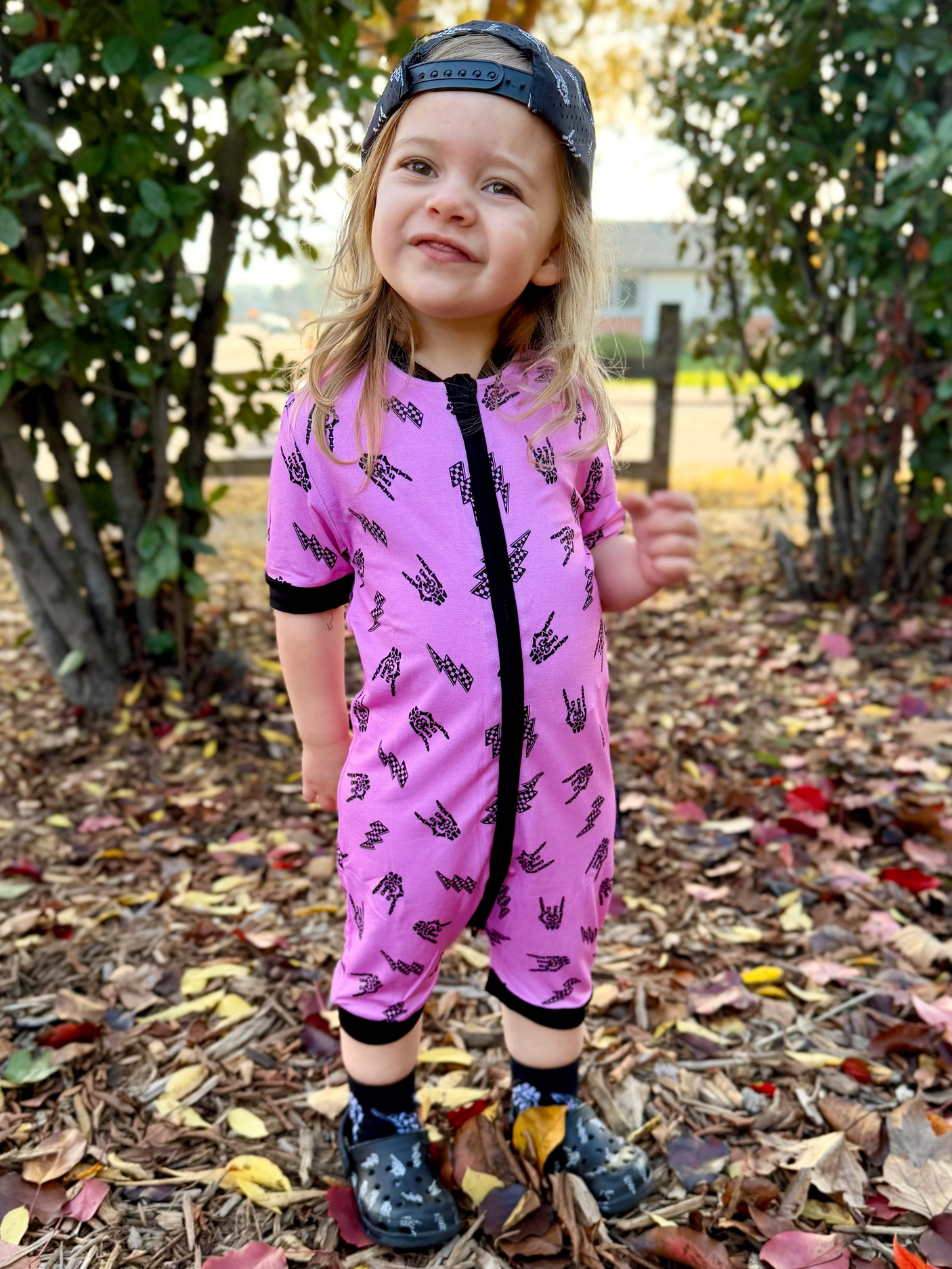 Pink bamboo baby shortie pajamas featuring an edgy rock-inspired print, made from ultra-soft breathable fabric, designed for babies and toddlers up to size 5T with a comfy stretchy fit and short sleeves for warmer nights