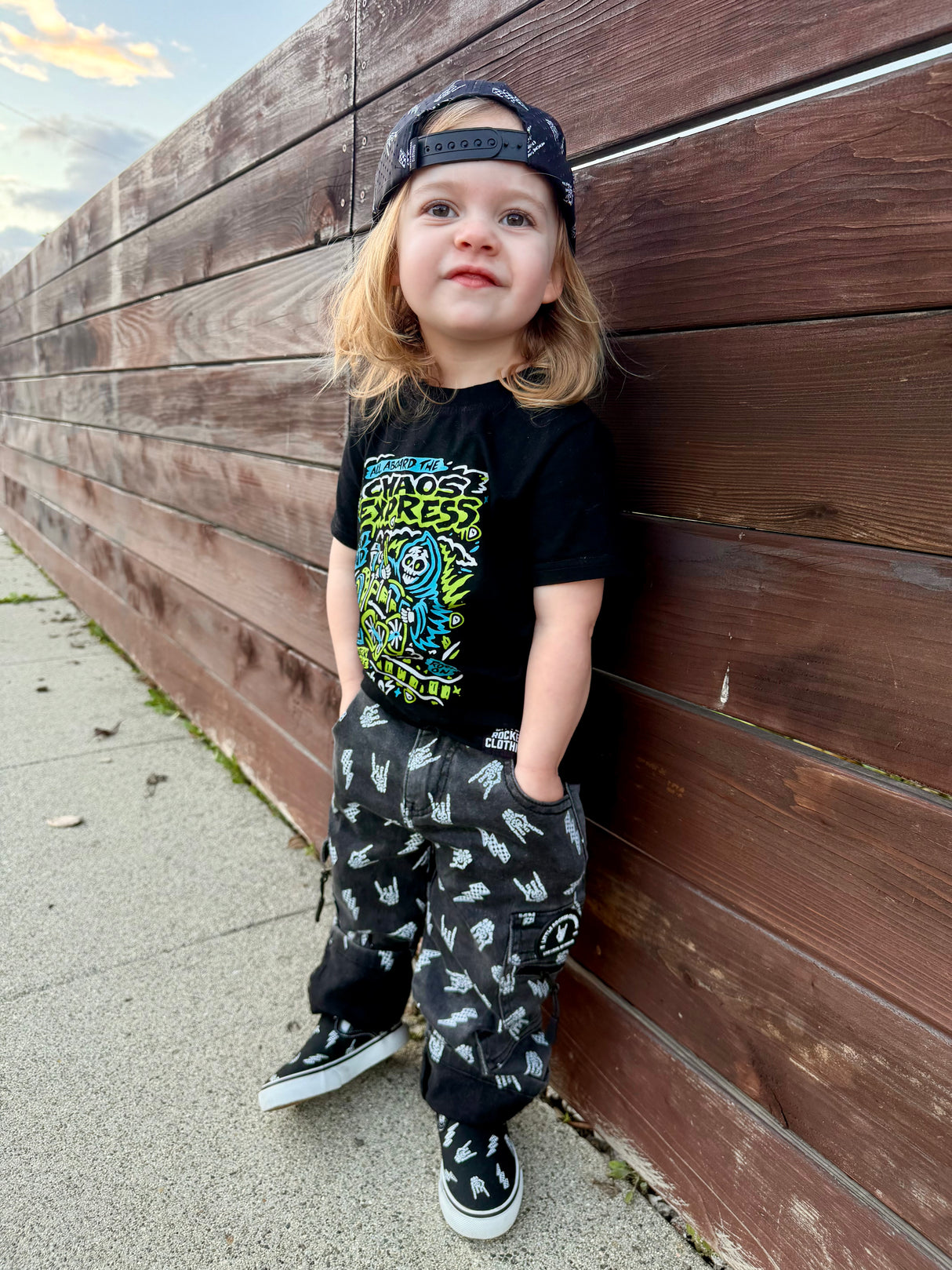 kids outfit featuring black washed baggy jeans with skull pattern edgy kids clothing and rock kids clothing style
