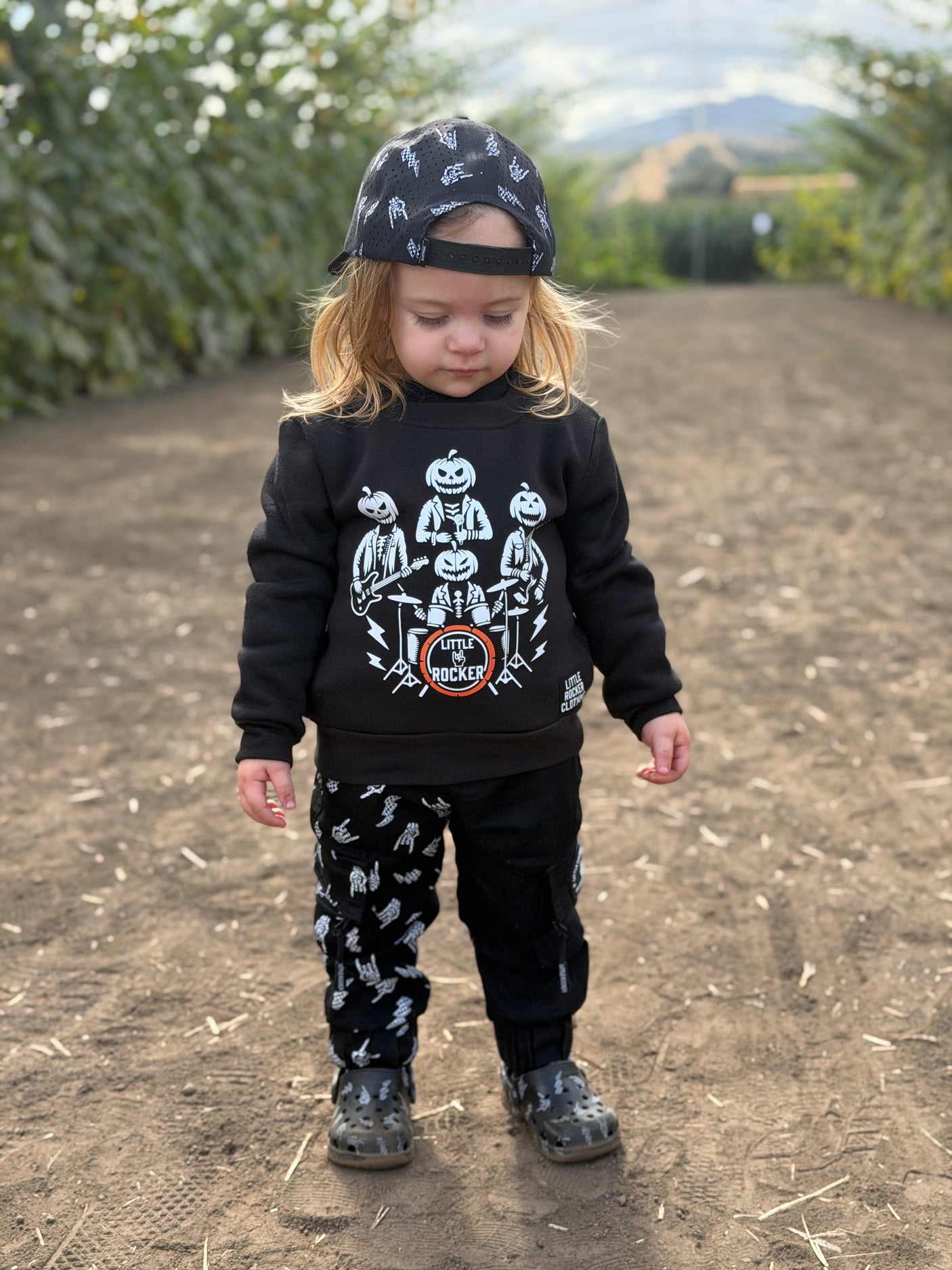 Toddler wearing rock music inspired halloween crew neck featuring a band of pumpkin heads from little rocker clothing