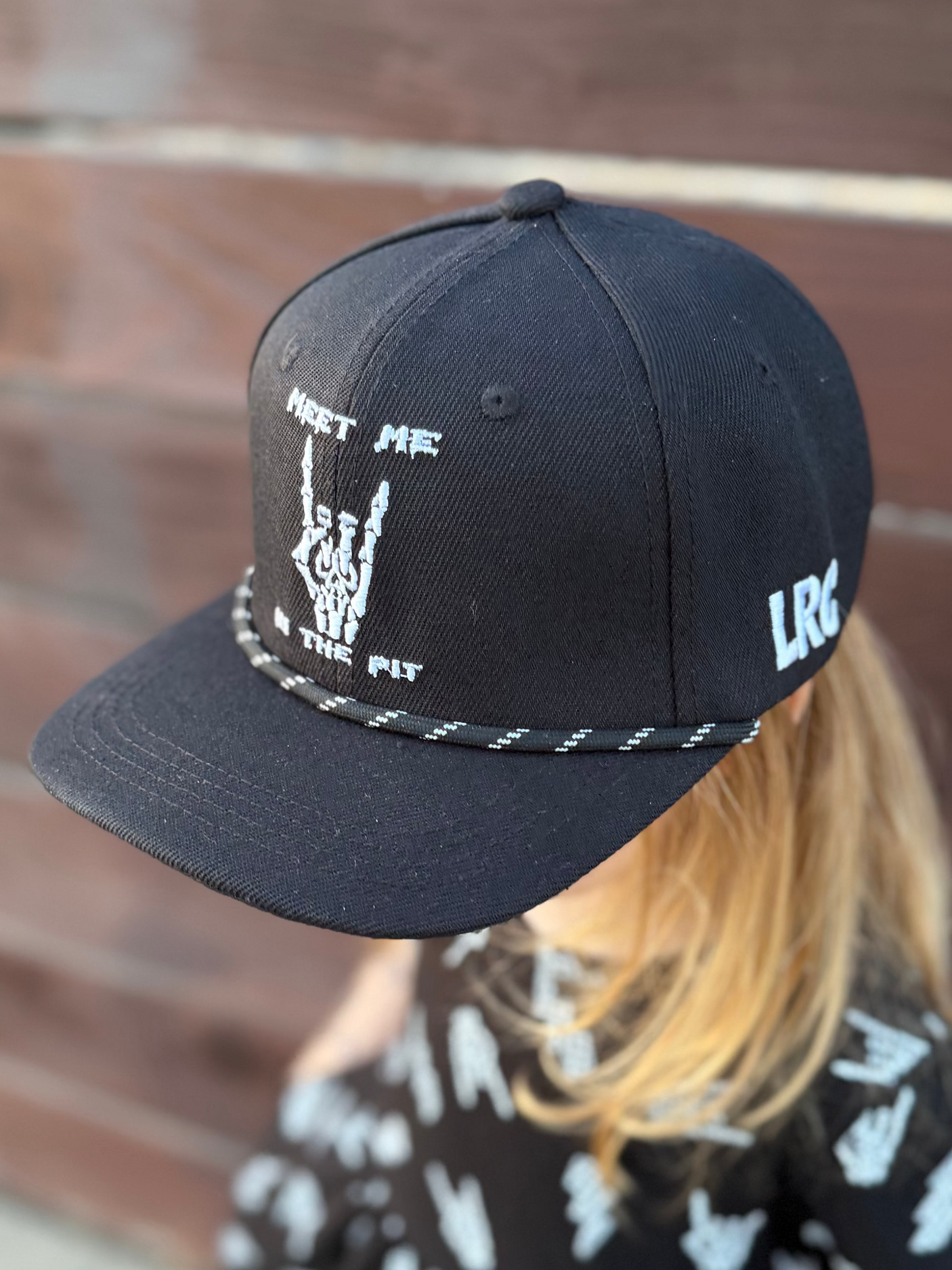 Kid wearing Little Rocker Clothing meet me in the pit black snapback hat, adjustable snapback cap for kids and adults, edgy rock music inspired apparel accessory