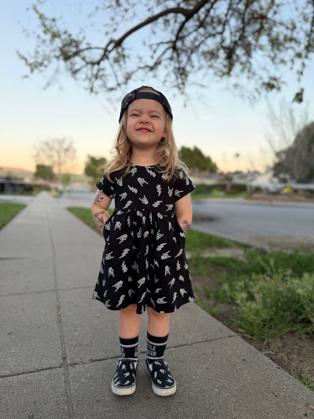 toddler wearing black bolted bones dress with skull print from Little Rocker Clothing alternative kids clothing edgy kids outfit