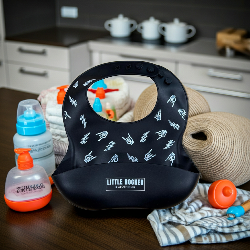 A black silicone baby bib with a white hand-drawn rocker style pattern for punk and rocker parents