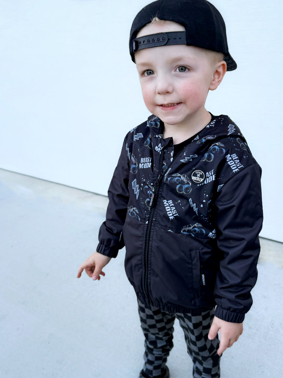 Toddler wearing Beast Mode black windbreaker jacket with all over graphic print, lightweight rocker style outerwear for kids with zip front and hood