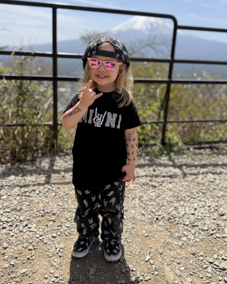 toddler girl giving the horns while wearing a rock inspired outfit from little rocker clothing