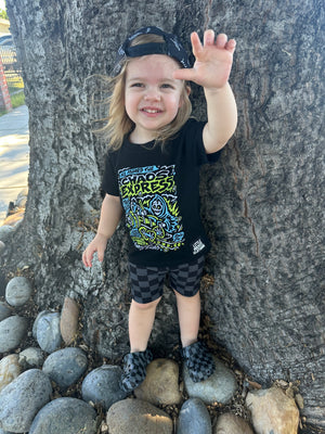 Girl playing in the Kids black chaos express t-shirt featuring rock inspired graphic with train illustration on a graphic tee, rocker style kids apparel