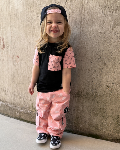 young girl wearing pink straight leg jeans and bolted bones pattern with hands in the pockets