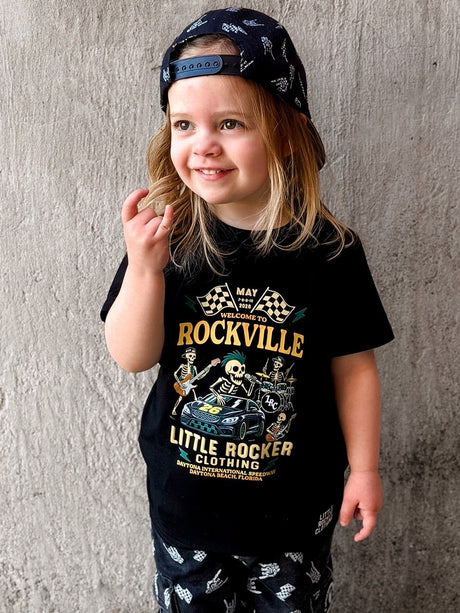 Girl wearing the official welcome to rockville kids graphic tee collaboration, rock festival band style t shirt for kids, black rocker tee with bold music design, little rocker clothing festival apparel