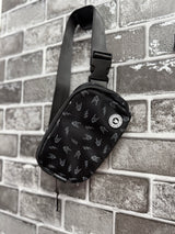Little Rocker Clothing black Bolted Bones crossbody bag featuring signature skull bolt pattern, adjustable strap crossbody purse with compact functional design, edgy rock style accessory for everyday wear