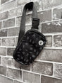 Little Rocker Clothing black Bolted Bones crossbody bag featuring signature skull bolt pattern, adjustable strap crossbody purse with compact functional design, edgy rock style accessory for everyday wear