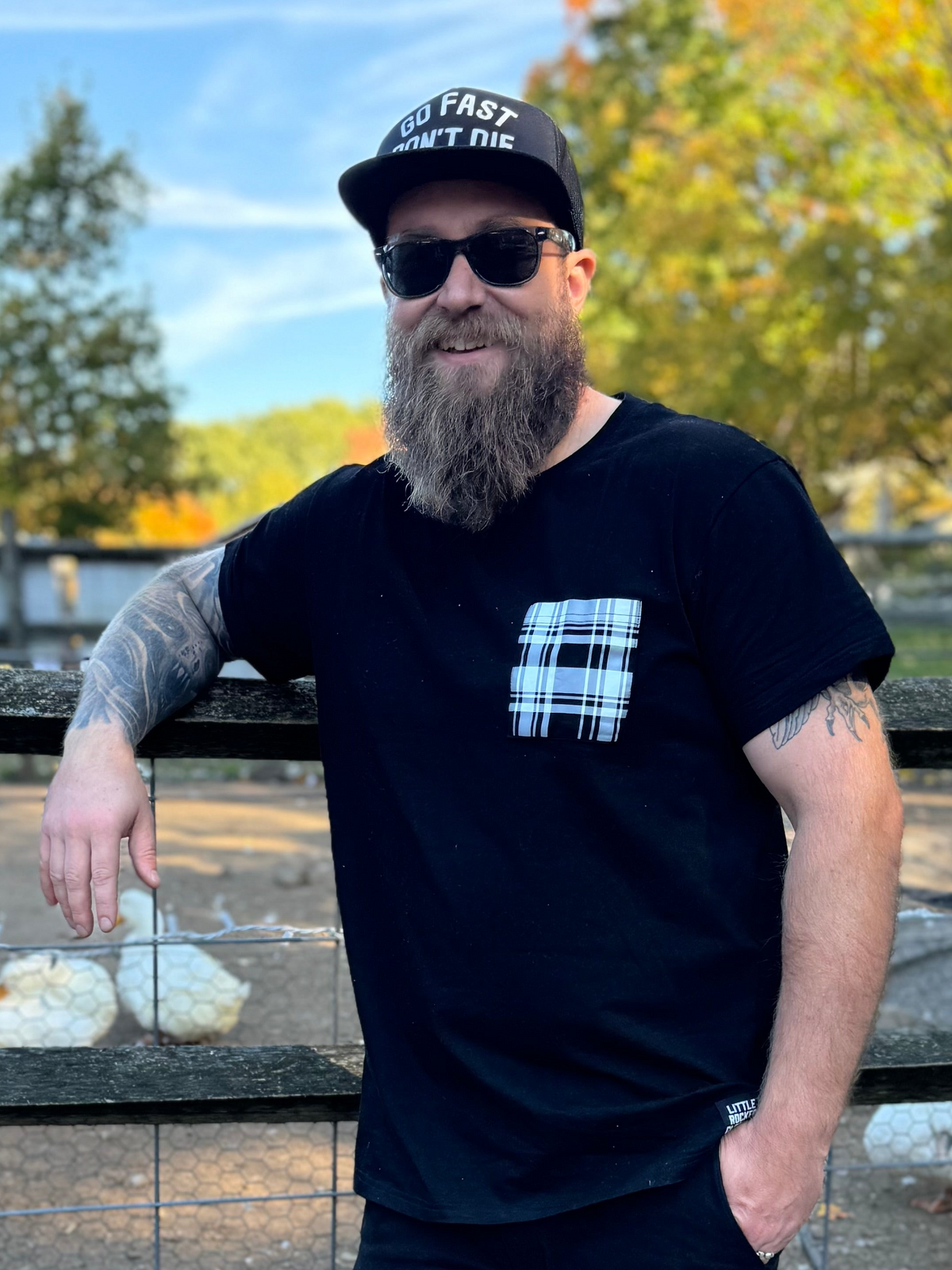 adult man wearing a little rocker clothing black tshirt with white plaid pocket
