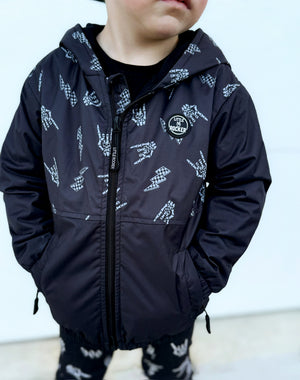 Close up of Kids bolted bones black windbreaker jacket with all over graphic print, lightweight rocker style outerwear for kids with zip front and hood