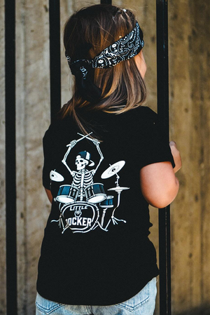 black kids graphic t-shirt with skeleton playing drums, little rocker clothing rock style outfit for toddlers and kids outdoors rear view