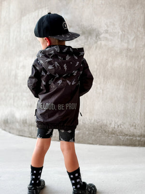 Kids bolted bones black windbreaker jacket with all over graphic print, live loud be proud on back side of the lightweight rocker style outerwear for kids with zip front and hood