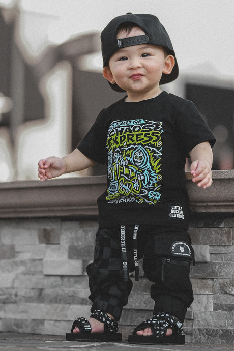 Young boy wearing the Kids black chaos express t-shirt featuring rock inspired graphic with train illustration on a graphic tee, rocker style kids apparel