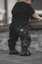 infant wearing kids half black half checkered cargo joggers black streetwear pants with cargo pockets rocker style toddler to youth sizes little rocker clothing