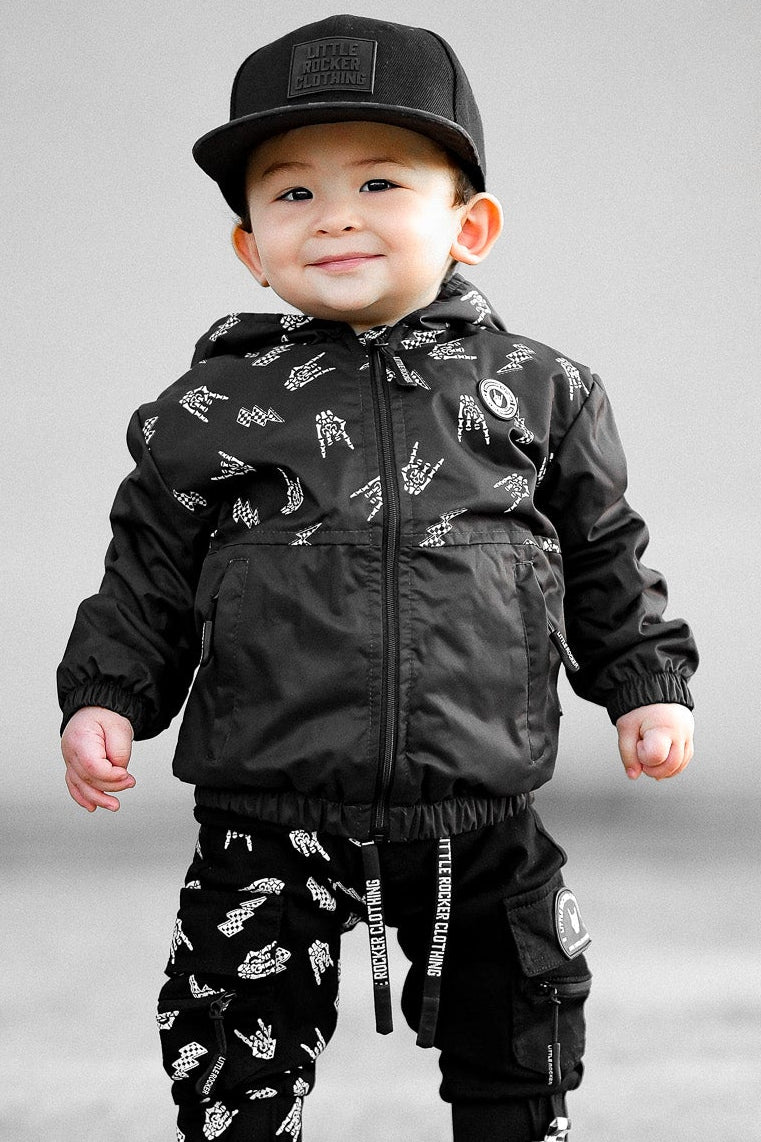Young toddler wearing Kids bolted bones black windbreaker jacket with all over graphic print, lightweight rocker style outerwear for kids with zip front and hood