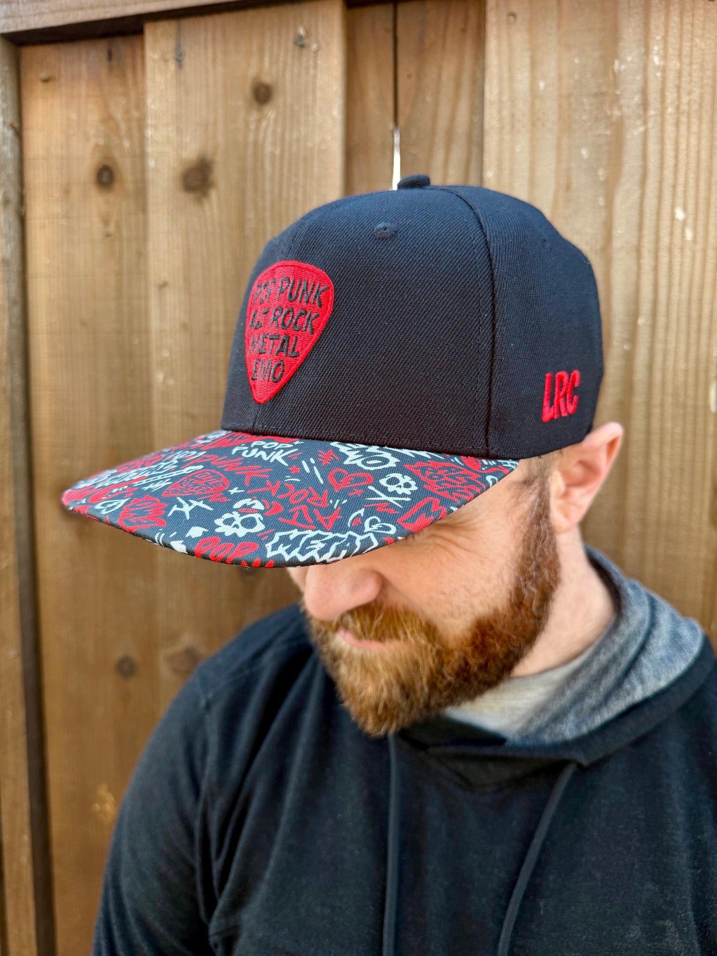 Kid wearing black and red Scene Sampler snapback hat featuring bold music inspired design, adjustable snapback cap for kids and adults, edgy rock style apparel accessory