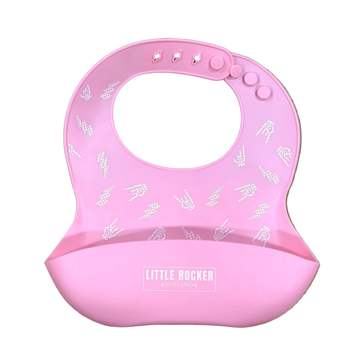 A pink silicone baby bib with a chin cup, featuring a white pattern of small boats on the upper portion and a white 'LITTLE ROCKER' brand label on the lower cup, displayed flat on a light wood grain background.