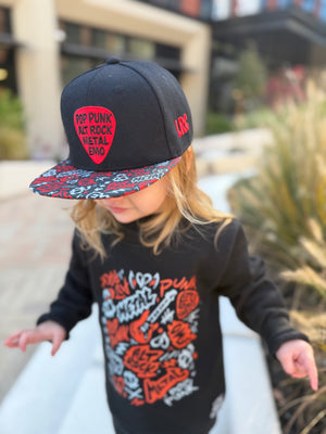 Kid wearing black and red Scene Sampler snapback hat featuring bold music inspired design, adjustable snapback cap for kids and adults, edgy rock style apparel accessory