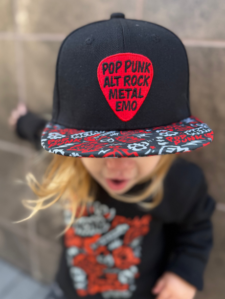 Kid wearing black and red Scene Sampler snapback hat featuring bold music inspired design, adjustable snapback cap for kids and adults, edgy rock style apparel accessory
