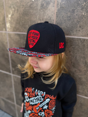 Kid wearing black and red Scene Sampler snapback hat featuring bold music inspired design, adjustable snapback cap for kids and adults, edgy rock style apparel accessory