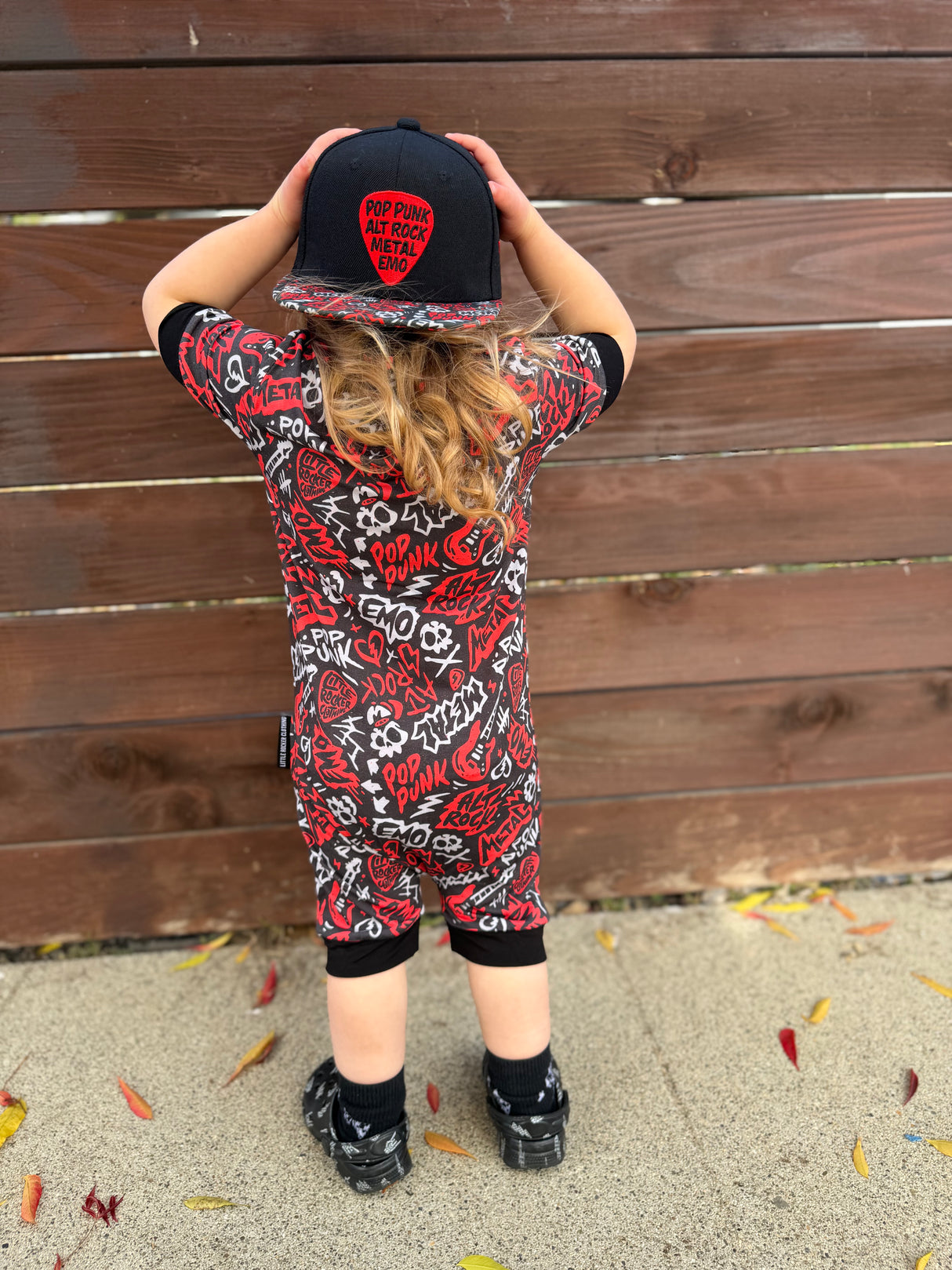 Black and Red baby pajamas featuring an edgy rock-inspired print, made from ultra-soft breathable fabric, designed for babies and toddlers up to size 5T with a comfy stretchy fit and short sleeves and short pant legs for warmer nights paired with a rock inspired snapback. 