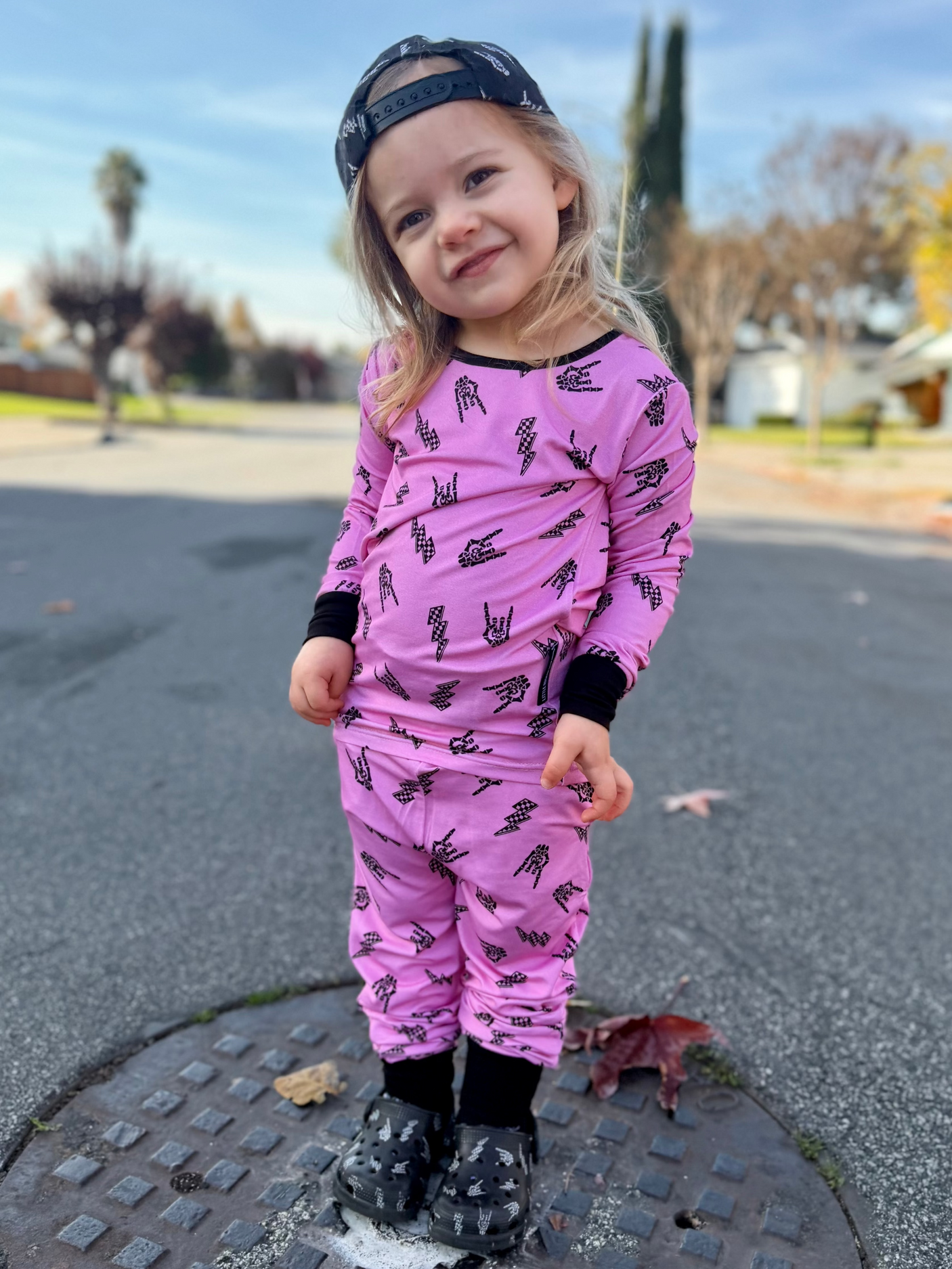 Pink bamboo two piece pajama set with long sleeves and full length pants, featuring an edgy rock inspired print, made from ultra soft breathable bamboo fabric with a stretchy comfortable fit for toddlers and kids in sizes 2T to 10/12