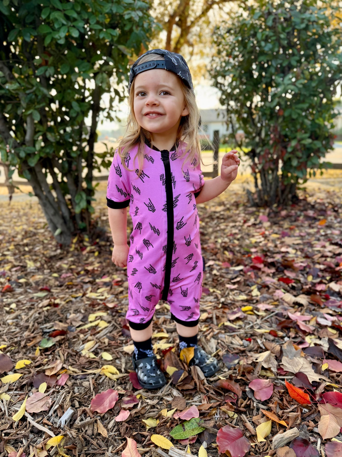Pink bamboo baby shortie pajamas featuring an edgy rock-inspired print, made from ultra-soft breathable fabric, designed for babies and toddlers up to size 5T with a comfy stretchy fit and short sleeves for warmer nights