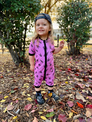 Pink bamboo baby shortie pajamas featuring an edgy rock-inspired print, made from ultra-soft breathable fabric, designed for babies and toddlers up to size 5T with a comfy stretchy fit and short sleeves for warmer nights
