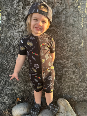 toddler girl outside wearing emo nights pattern short sleeve zip up pajamas for kids