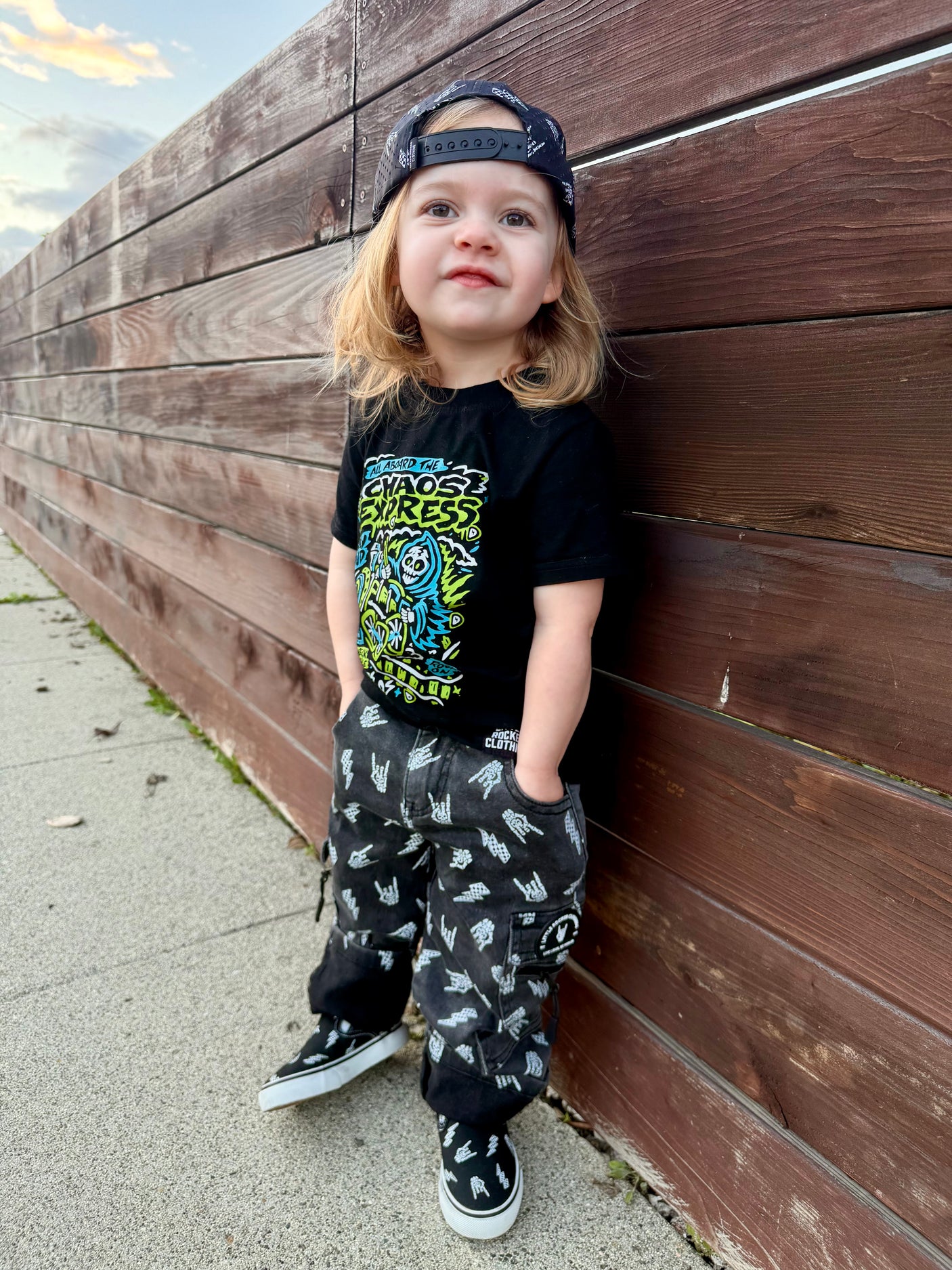 kids outfit featuring black washed baggy jeans with skull pattern edgy kids clothing and rock kids clothing style