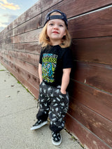kids outfit featuring black washed baggy jeans with skull pattern edgy kids clothing and rock kids clothing style