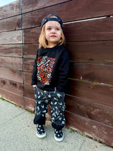 kids outfit featuring black washed baggy jeans with skull pattern edgy kids clothing and rock kids clothing style