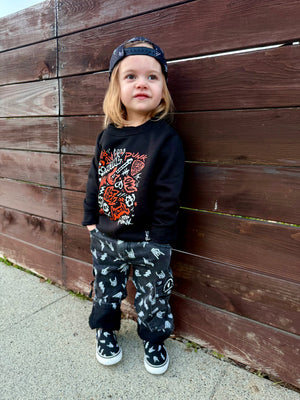 kids outfit featuring black washed baggy jeans with skull pattern edgy kids clothing and rock kids clothing style