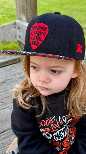 Kid wearing black and red Scene Sampler snapback hat featuring bold music inspired design, adjustable snapback cap for kids and adults, edgy rock style apparel accessory