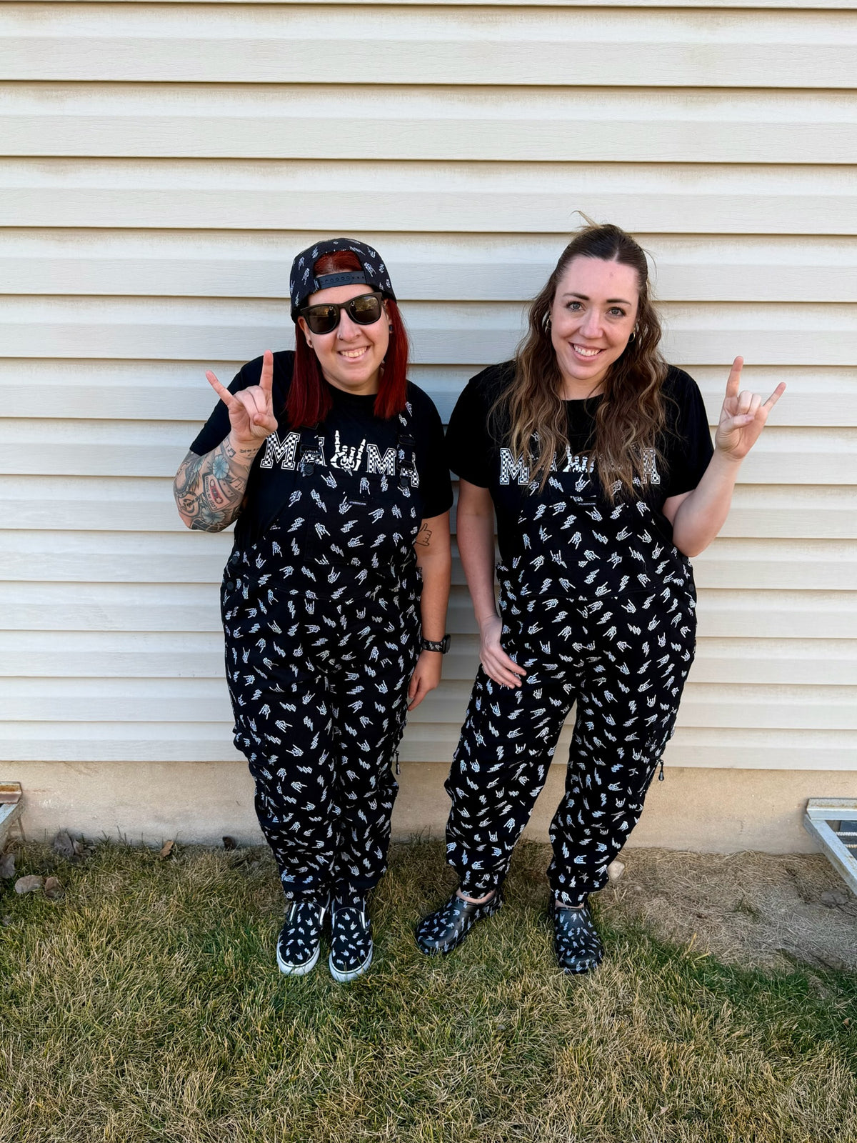 two adults wearing black bolted bones overalls styled as edgy alternative outfits from Little Rocker Clothing