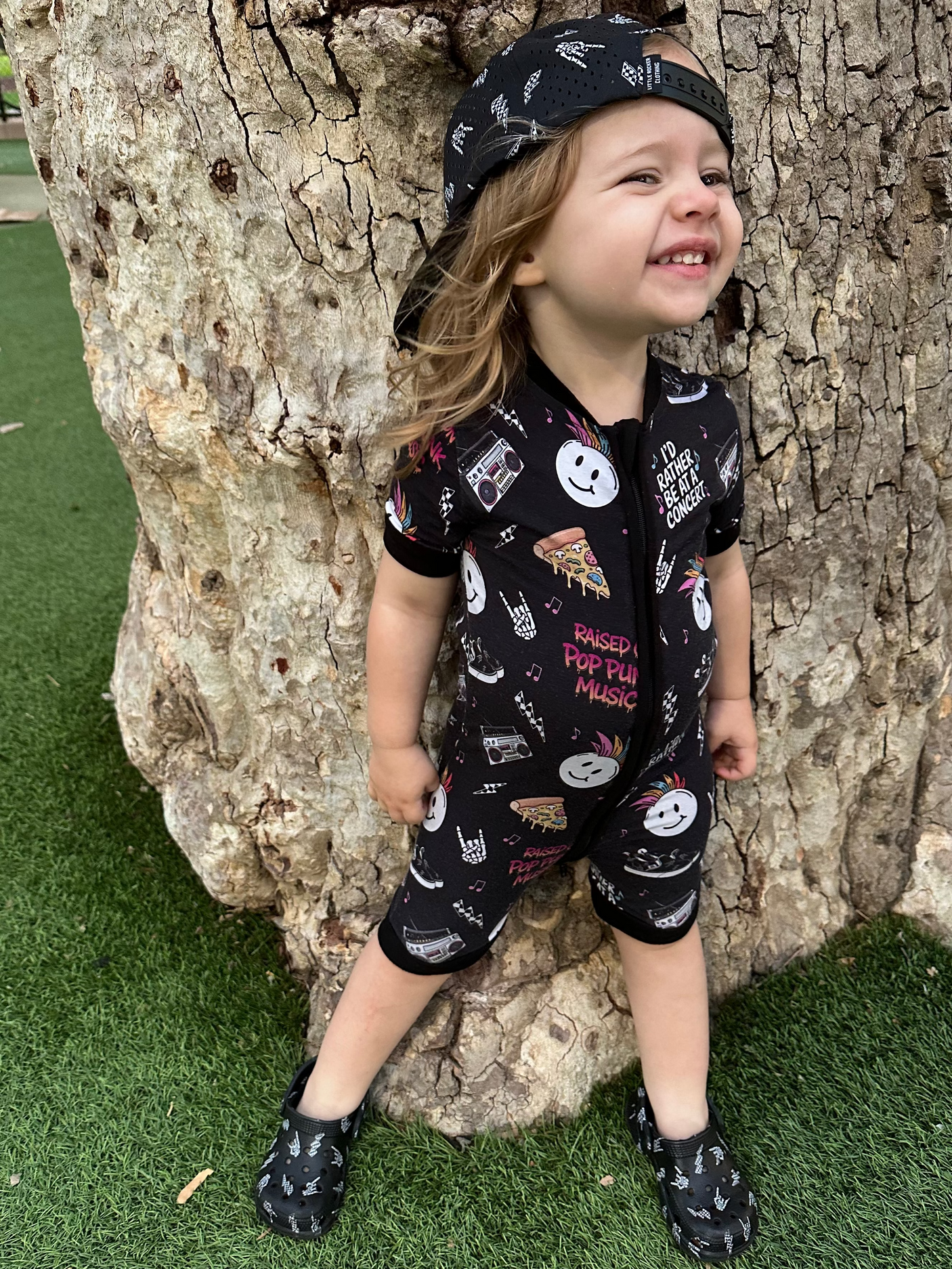 toddler wearing pop punk collage pattern short sleeve zip up bamboo pajamas for kids