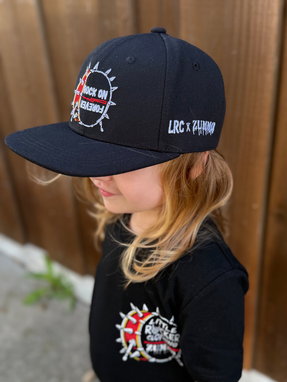 Kid wearing Frank Zummo collaboration with Little Rocker Clothing snapback hat with drum graphic and rock on forever phrase, edgy rock style kids hat with adjustable fit, music inspired youth apparel accessory