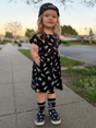 young girl wearing bolted bones pattern black dress