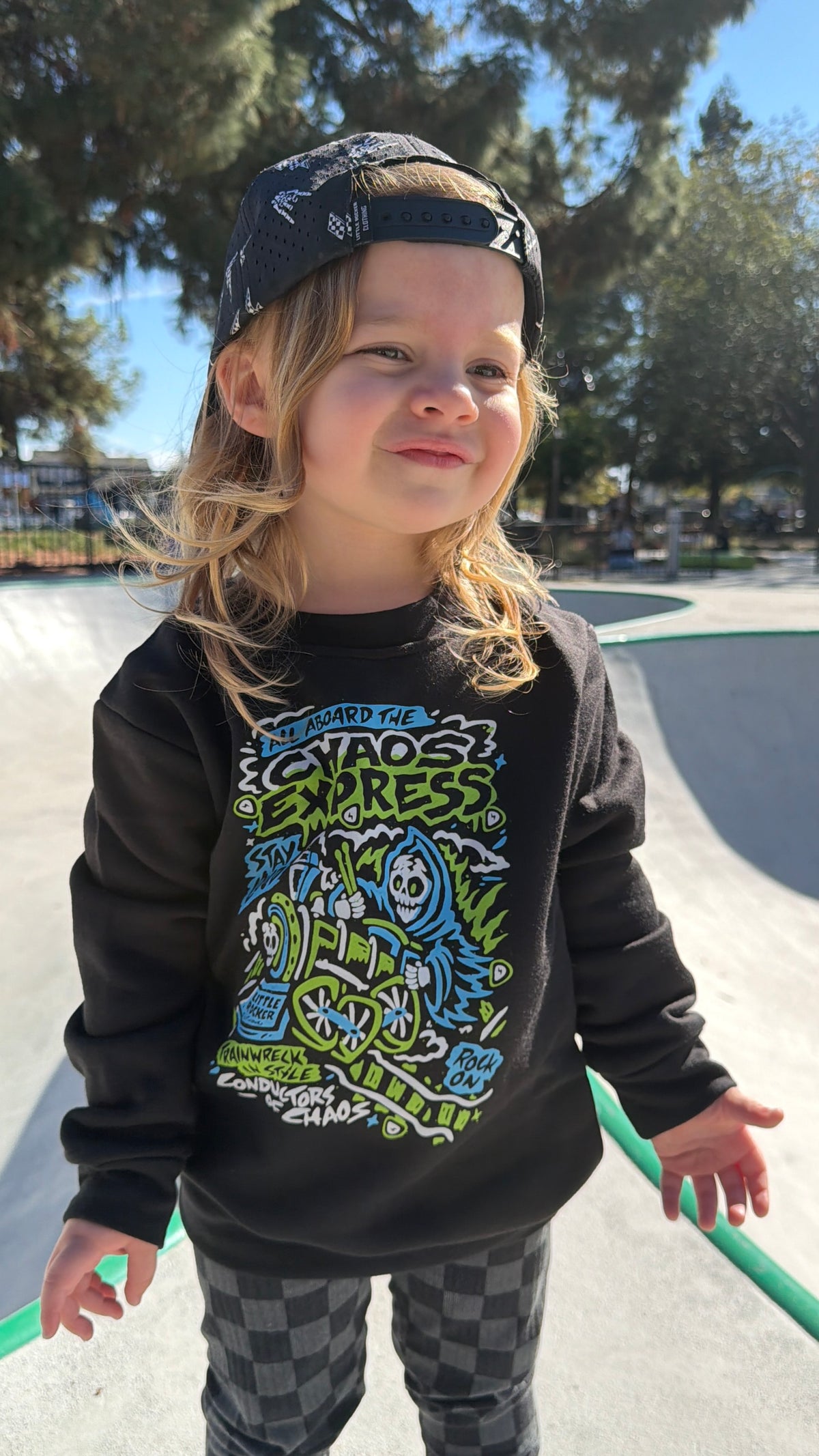 Toddler girl wearing the Kids black Scene Sampler crew neck sweatshirt featuring pop punk, emo, and alt rock graphic with train illustration, rocker style kids apparel