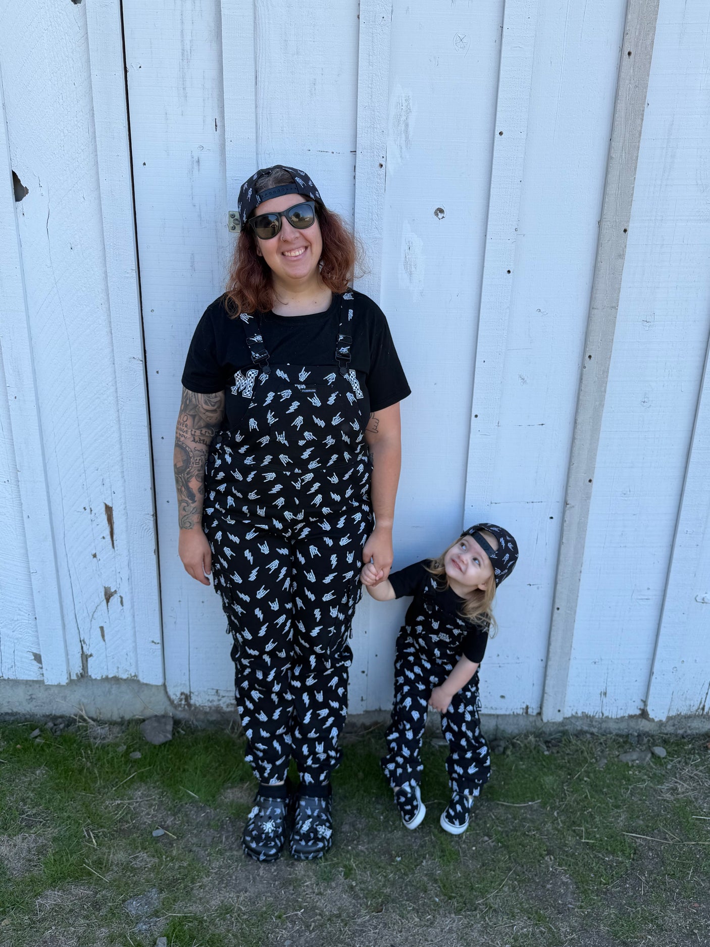 parent and toddler wearing black overalls with skull pattern styled as rock kids clothing and matching family outfits