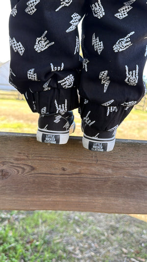 bolted bones canvas slip on shoes for kids with black and white skull and lightening bolt pattern, rocker style kids sneakers, elastic slip on design, little rocker clothing footwear back side with rubber emblem