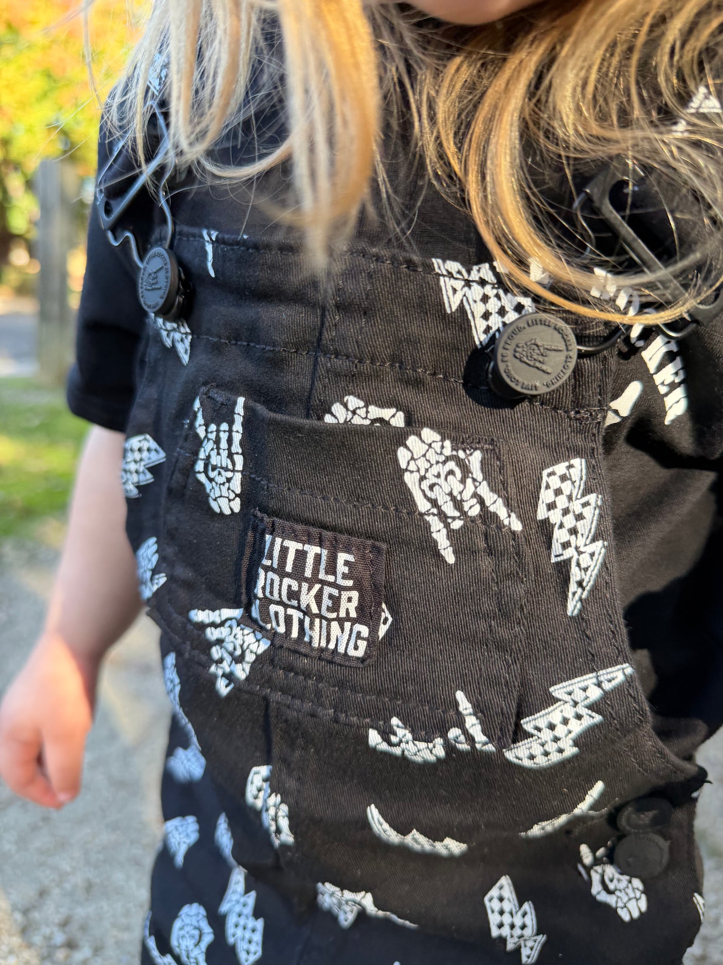 close up of kids black bolted bones overalls with lightning bolt and rock hand print matching outfits toddler streetwear little rocker clothing