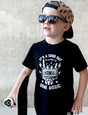 black kids graphic t-shirt with with it's a nice day to listen to some music, little rocker clothing punk rock toddler outfit front view smiling child outdoors