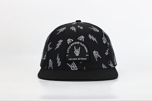 close up black snapback hat with allover bolted bones lightning bolt and rock hand print little rocker clothing patch flat brim adjustable cap for kids and adults